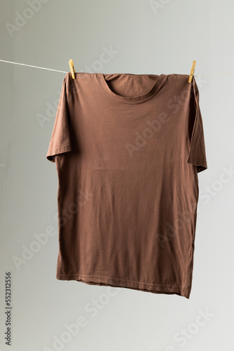 Close up of hanging brown tshirt and copy space on white background