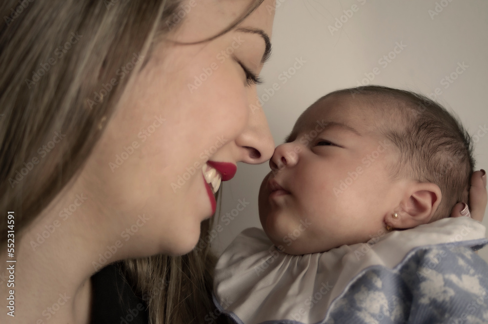Mother and newborn daughter holding nose together. Mother and newborn daughter holding nose together.