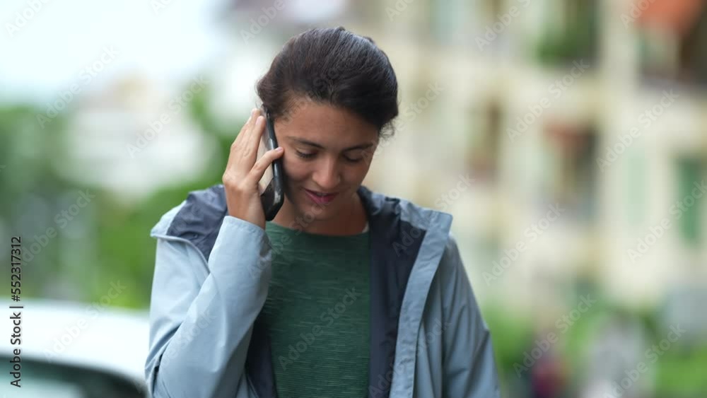 One candid happy woman speaking on phone outdoors. Authentic female person talking with smartphone in conversation One candid happy woman speaking on phone outdoors. Authentic female person talking with smartphone in conversation
