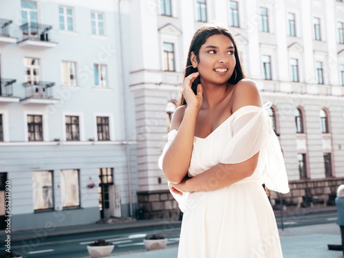 Free Download Young beautiful smiling hipster woman in white dress. Sexy carefree model posing on the street background at sunset. Positive female outdoors at warm sunny day. Cheerful and happy - GFXLoad