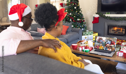 Senior african american couple having christmas video call with diverse people