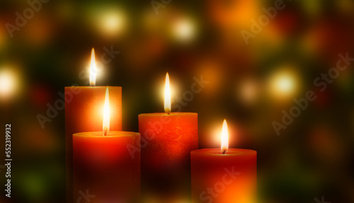 four red burning candles on bright festive christmas background  magic contemplative mood with unfocused lights