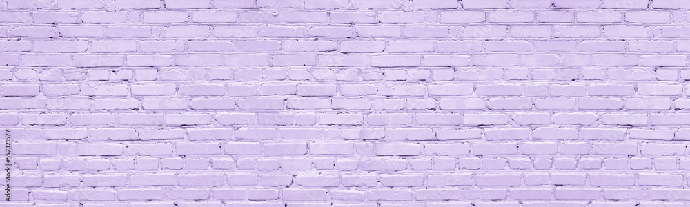 Pastel lavender color painted old brick wall wide texture. Light violet rough brickwork. Grunge panoramic background