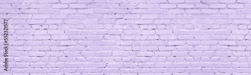 Pastel lavender color painted old brick wall wide texture. Light violet rough brickwork. Grunge panoramic background