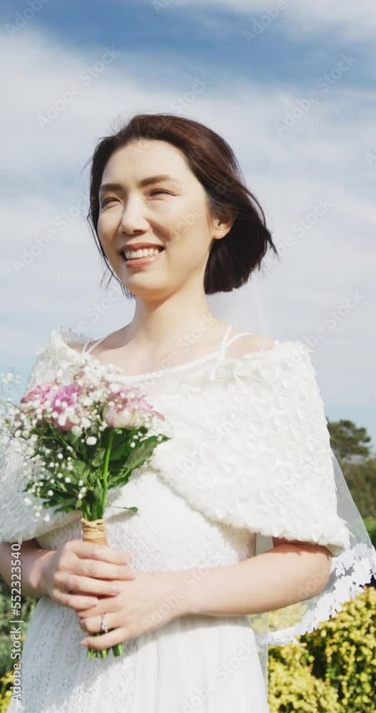 Vertical video of happy asian bride holding bouquet and smiling at outdoor wedding Vertical video of happy asian bride holding bouquet and smiling at outdoor wedding