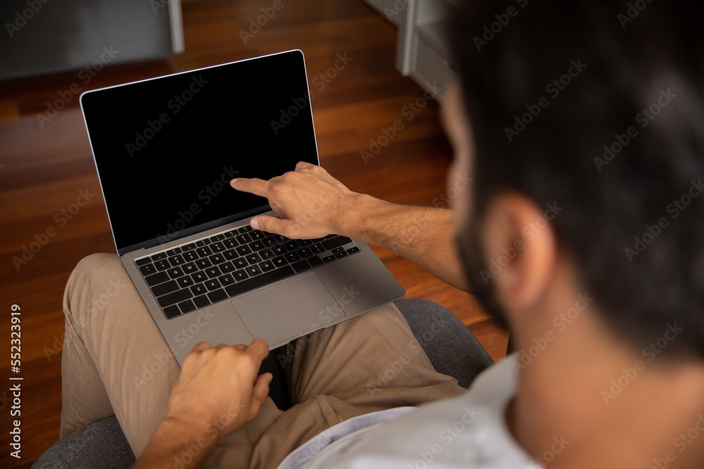 person working on laptop, man showing computer screen, young man pointing to notebook screen with his finger, in the foreground his face appears blurred person working on laptop, man showing computer screen, young man pointing to notebook screen with his finger, in the foreground his face appears blurred