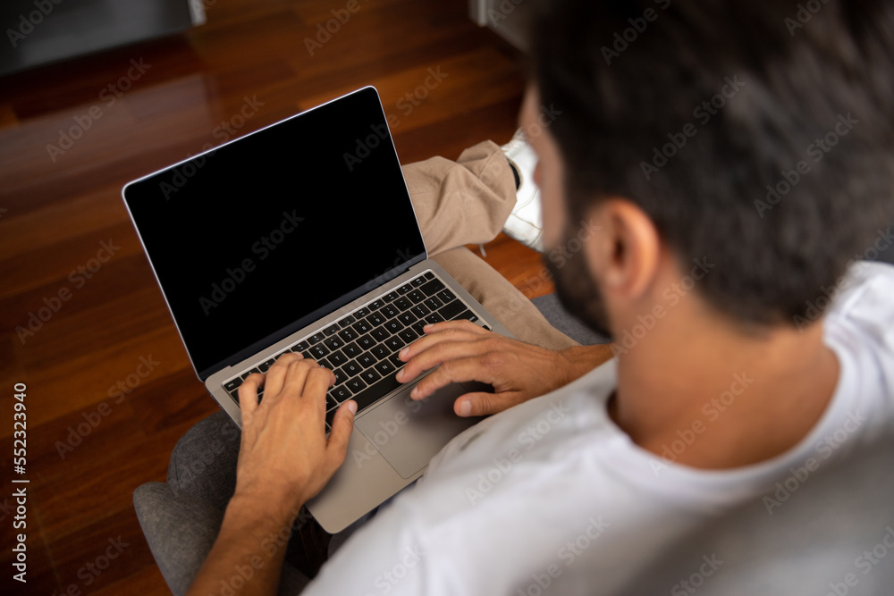 man working on laptop, man typing on his computer, young man typing on notebook, in the foreground his face appears blurred man working on laptop, man typing on his computer, young man typing on notebook, in the foreground his face appears blurred