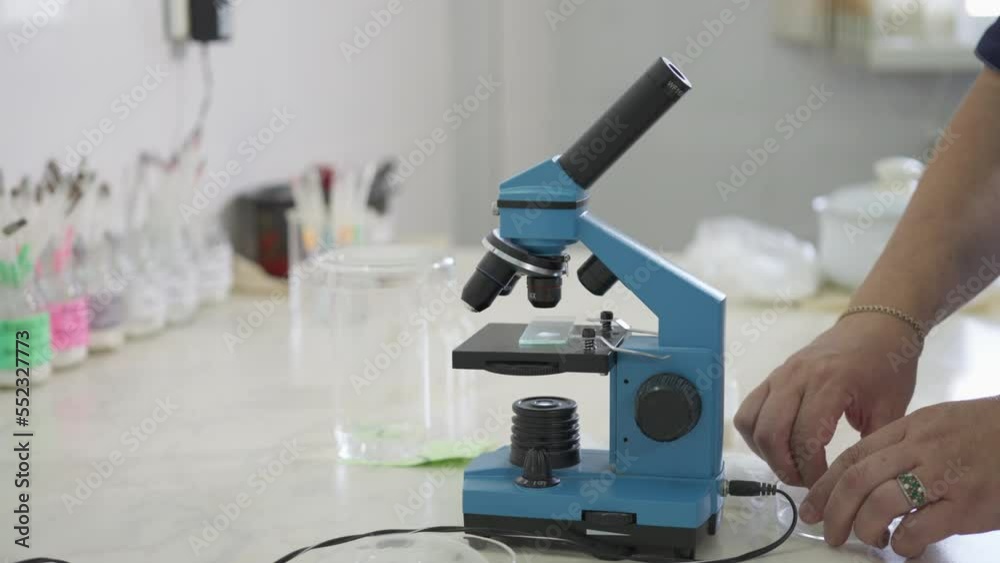 Using microscope equipment for the analysis of liquid product sample. Analysing the sample quality with a microscope tool. Worker analyses the substance sample with a microscope. Quality Inspection. Using microscope equipment for the analysis of liquid product sample. Analysing the sample quality with a microscope tool. Worker analyses the substance sample with a microscope. Quality Inspection.