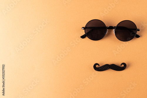 Composition of fake moustache and glasses on orange background with copy space © vectorfusionart