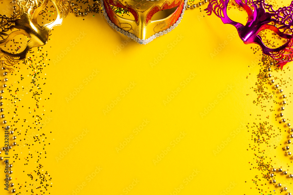 Composition of colourful mardi gras beads and carnival masks on yellow background with copy space - obrazy, fototapety, plakaty 