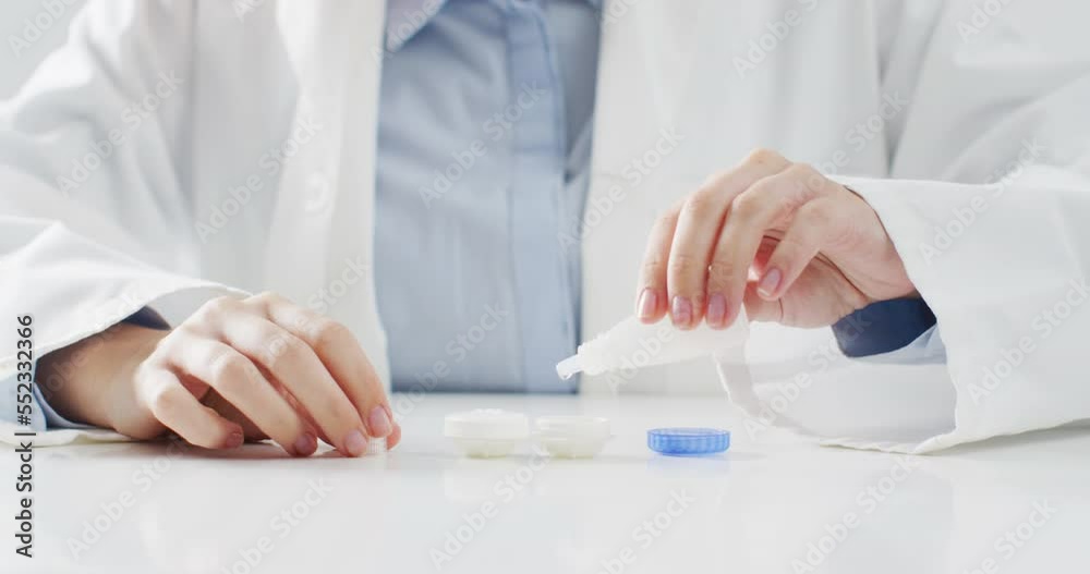 Video of midsection of caucasian doctor putting lens solution into contact lenses case Video of midsection of caucasian doctor putting lens solution into contact lenses case