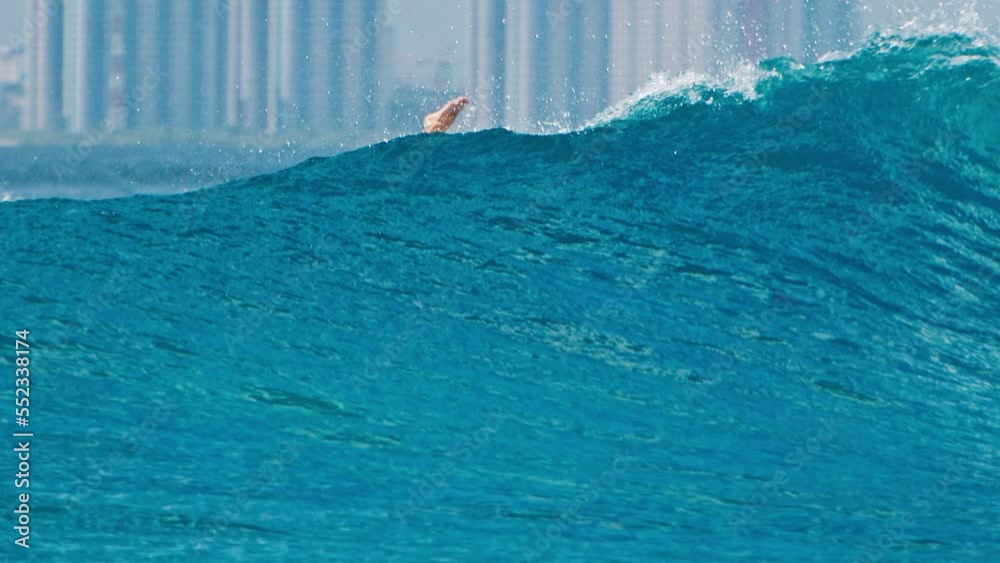 Woman surfer with longboard elegantly passes the wave