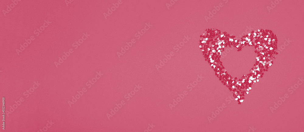 Heart shaped frame made of shiny sequins on a viva magenta background. Festive texture for Valentines Day, Mothers Day, Womens Day, day of the wedding and Birthday. Banner, Flatlay, copy space.