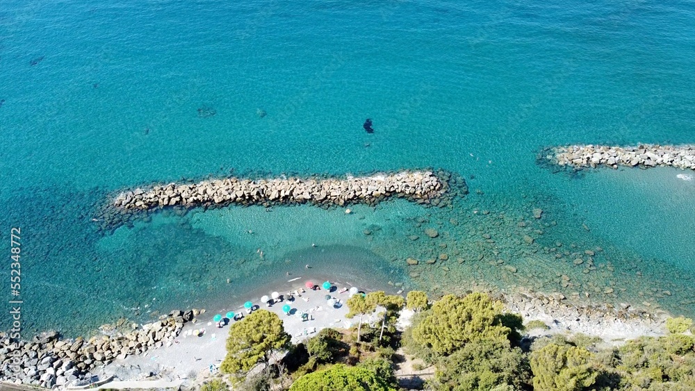 Liguria, Cinque Terre , drone aerial view of Framura a sea village with amazing blue sea and beach - Summer holidays in North Italy - rocks barrier  to protect the coast - increase sea level 