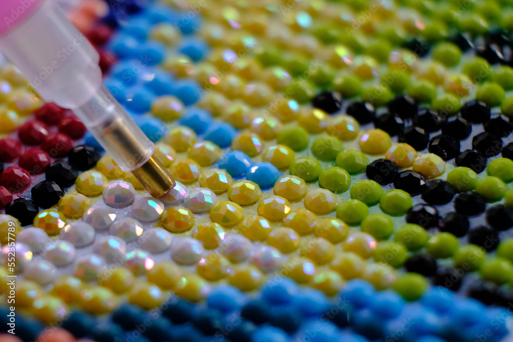 Diamond painting with pen closeup. art therapy concept. Laying out a