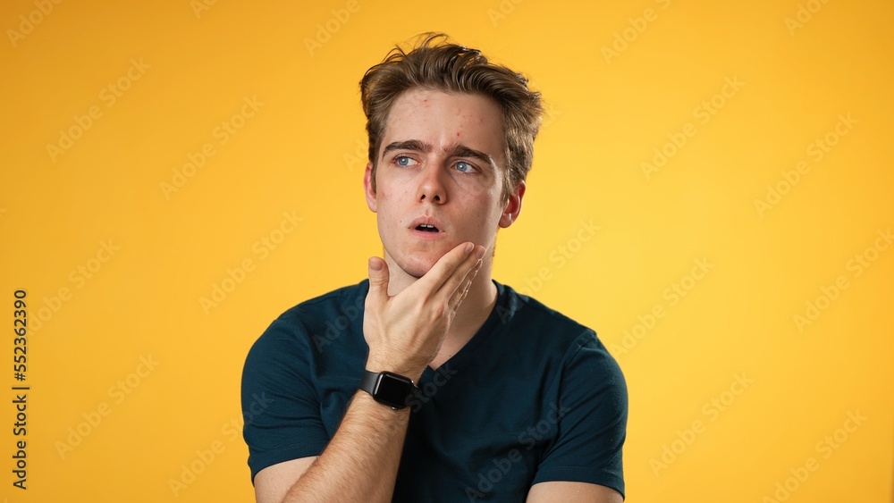 Portrait of thinking, smart puzzled pensive young hipster man 20s looks around thinks comes up with ideas raised finger isolated on yellow background studio portrait