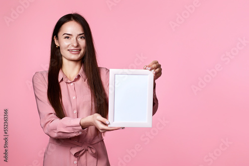 young woman in pink dress holding white frame