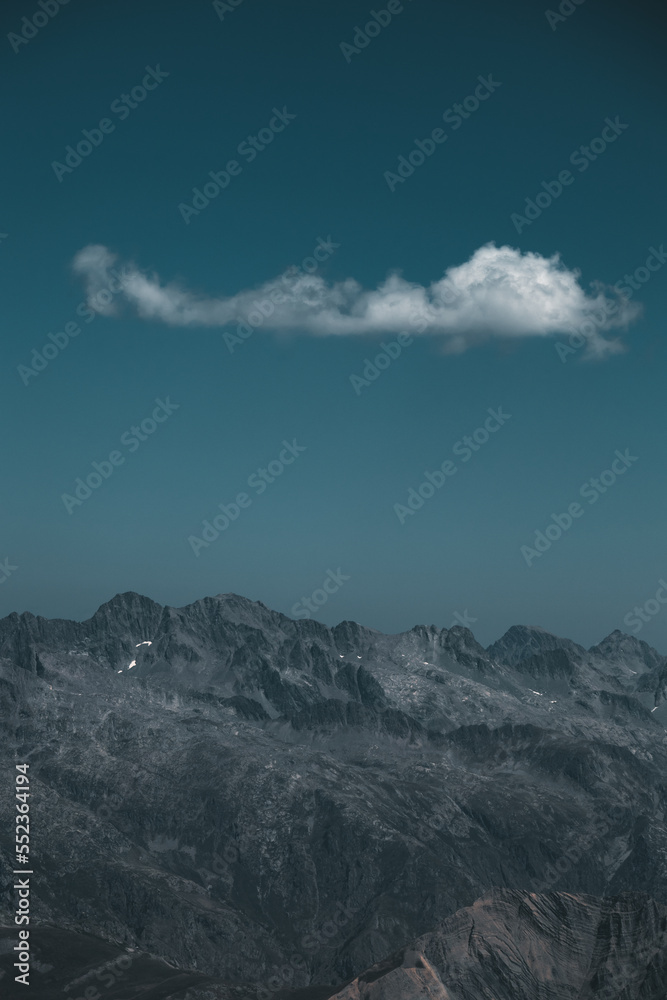 a single cloud is hanging above the mountains in the alps, France