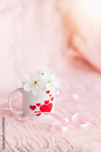 valentine's day concept. white cup for coffee with hearts on a pale pink background 