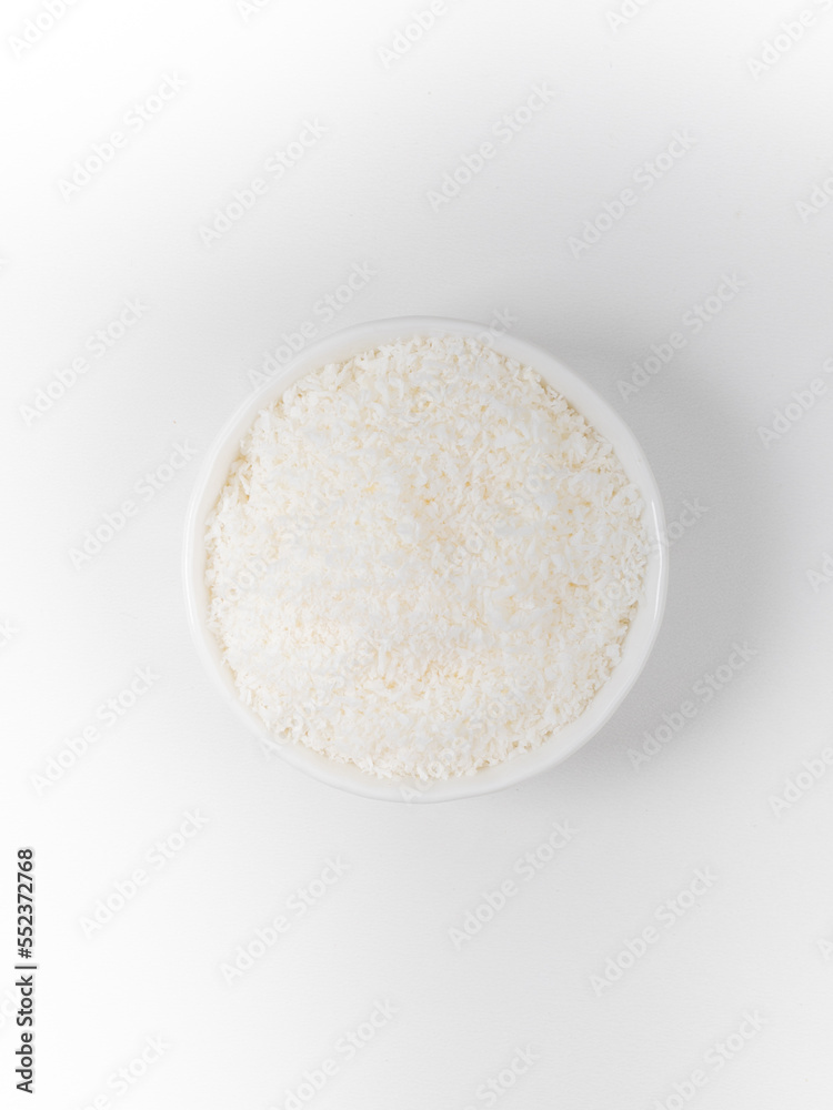 Heap of coconut in a bowl closeup isolated on white background Heap of coconut in a bowl closeup isolated on white background