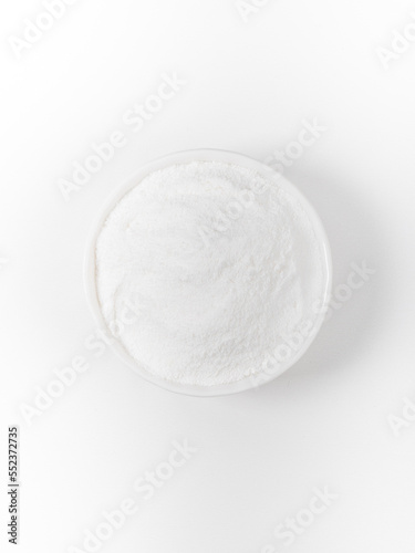 Dried coconut milk in a bowl closeup on white background isolated