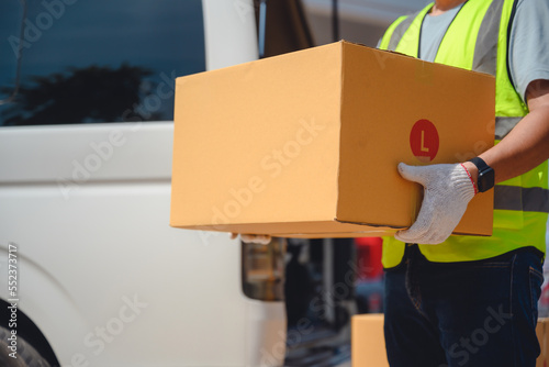 Asian workers have a career as a parcel delivery driver. Standing holding a cardboard box at the delivery van work for delivery driver home service © เลิศลักษณ์ ทิพชัย