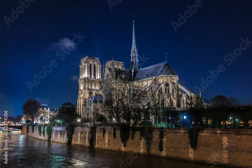 Illuminated Notre Dame de Paris Cathedral with the spire, before the fire at night, world most famous Gothic Roman Catholic cathedral in Paris, France