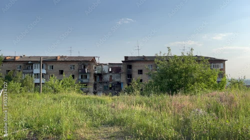 Blue sky, green Environment with Damaged and burnt out multi-storey houses in Ukraine, near Kyiv. Walls, broken windows of buildings. War destroyed peace life. Blue sky, green Environment with Damaged and burnt out multi-storey houses in Ukraine, near Kyiv. Walls, broken windows of buildings. War destroyed peace life.