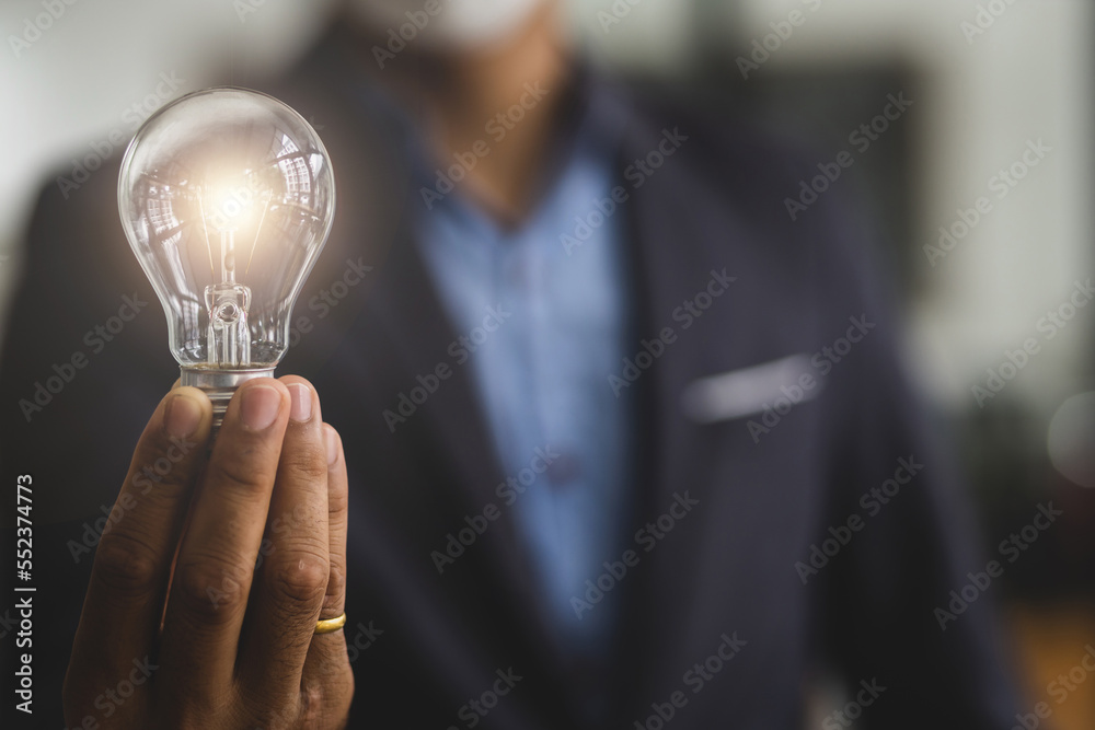 Businessman holding a light bulb, concept of idea. Businessman holding a light bulb, concept of idea.
