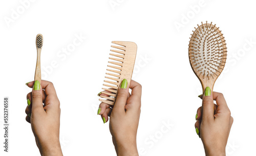 Woman hand holding eco friendly set of hairbrush, comb and toothbrush made of bamboo. Sustainability and eco friendly bathroom accessories photo