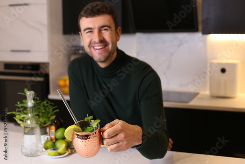 Man preparing a Moscow mule cocktail in copper cup