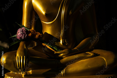 Photography Half buddha statue that holds flower, lotus and incesnse in his hand