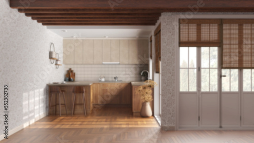 Blurred background, rustic wooden kitchen. Cabinets, island with stools, parquet floor. Door and window. Farmhouse interior design
