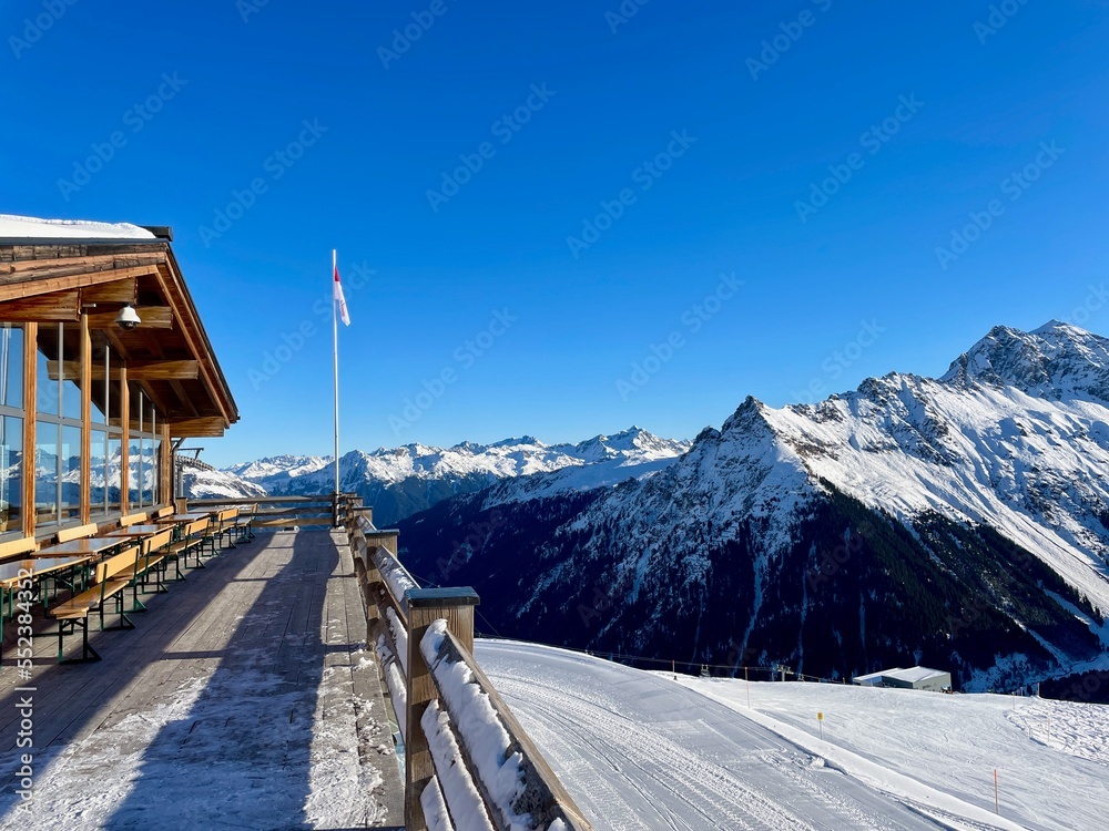 Terrace of mountain restaurant on a sunny winter day with spectacular view of the mountains in Gargellen, Montafon, Vorarlberg.