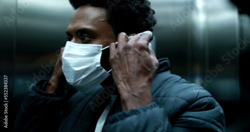 African american man wearing covid mask inside elevator, virus prevention