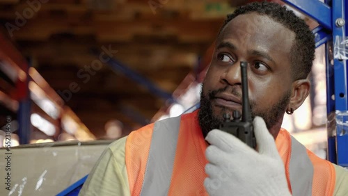 African American worker using walkie talkies in warehouse, warehousing, distribution, transport
