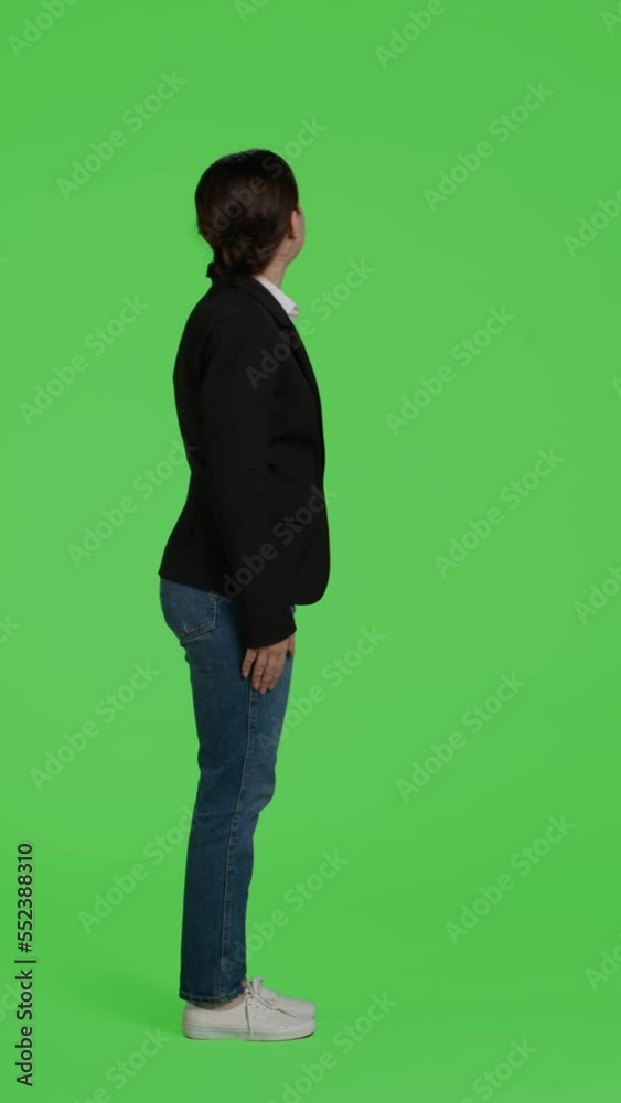 Vertical video: Profile of impatient office worker waiting and being late, standing over full body green screen background. Young businesswoman wait, wearing suit on studio isolated greenscreen Vertical video: Profile of impatient office worker waiting and being late, standing over full body green screen background. Young businesswoman wait, wearing suit on studio isolated greenscreen