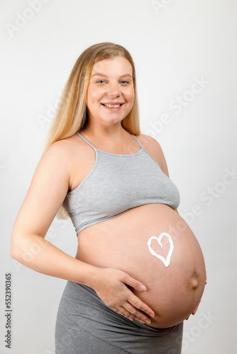 Cream on the stomach of a pregnant girl in the shape of heart. Skin care for a pregnant woman. Free Download Cream on the stomach of a pregnant girl in the shape of heart. Skin care for a pregnant woman. - GFXLoad