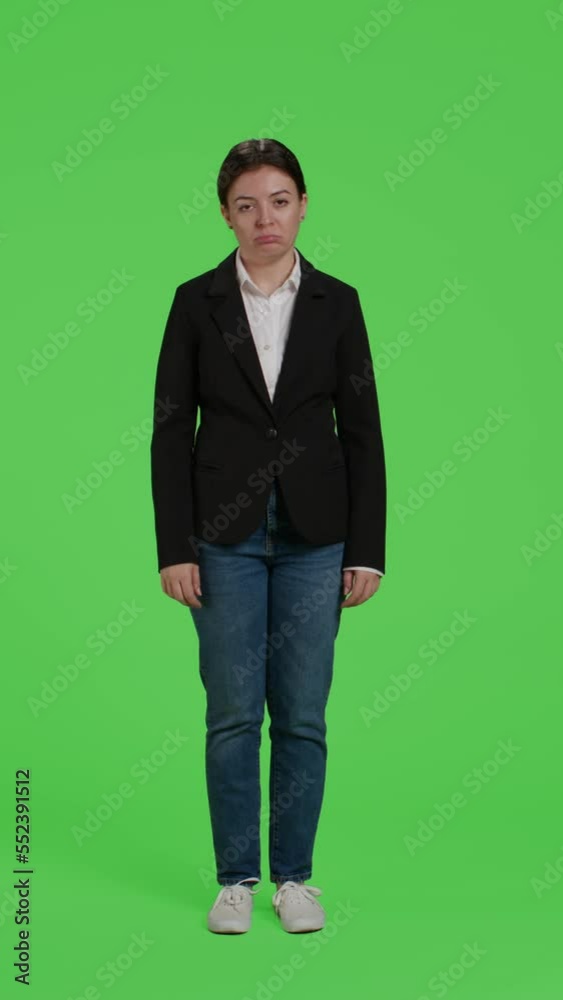 Vertical video: Front view of displeased company manager acting sad or upset in studio, feeling disappointed over full body greenscreen. Discontent female employee being negative posing on camera over Vertical video: Front view of displeased company manager acting sad or upset in studio, feeling disappointed over full body greenscreen. Discontent female employee being negative posing on camera over