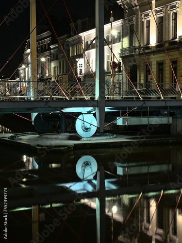 Illuminated Predeikherenbrug, cablestayed swing bridge over river Lys at night, with reflections in the water surface in Ghent, Flanders, Belgium  photo