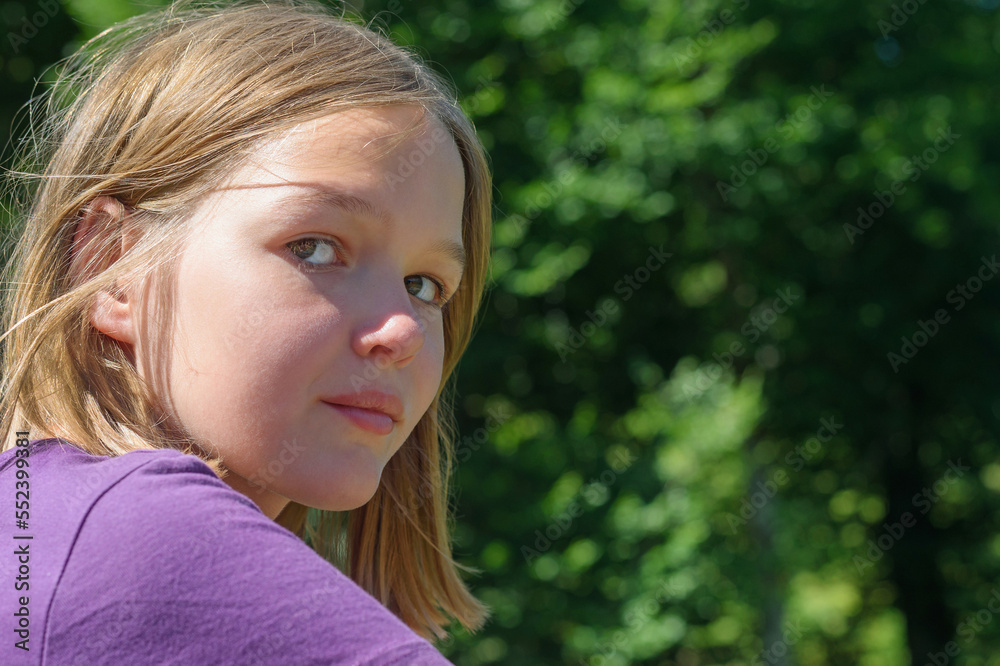 Teenager girl travels around area and examines destinations. Blonde teen schoolgirl looks with thoughtful and serious expression at sunlight Teenager girl travels around area and examines destinations. Blonde teen schoolgirl looks with thoughtful and serious expression at sunlight