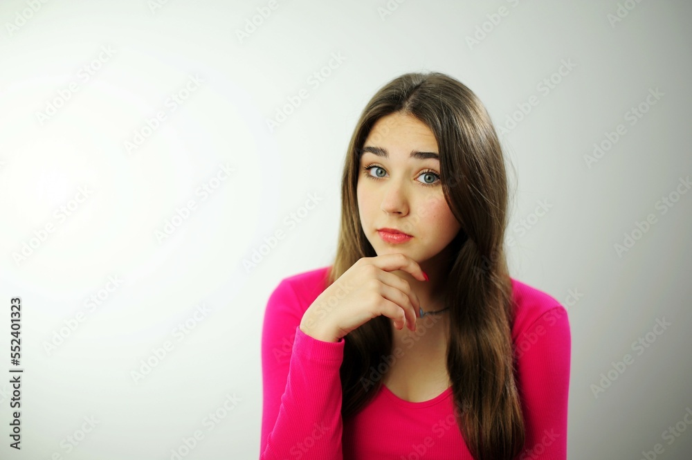 Many positive emotions joy happiness fun success Beautiful young woman girl with long brown hair in a pink sweater on a white background different emotions Place for text advertising sales Teenager Many positive emotions joy happiness fun success Beautiful young woman girl with long brown hair in a pink sweater on a white background different emotions Place for text advertising sales Teenager