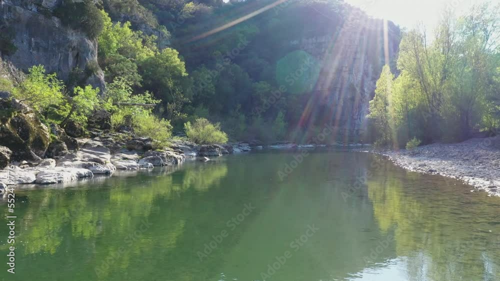 aerial shot over clear calm water Herault river along a canyon limestone France