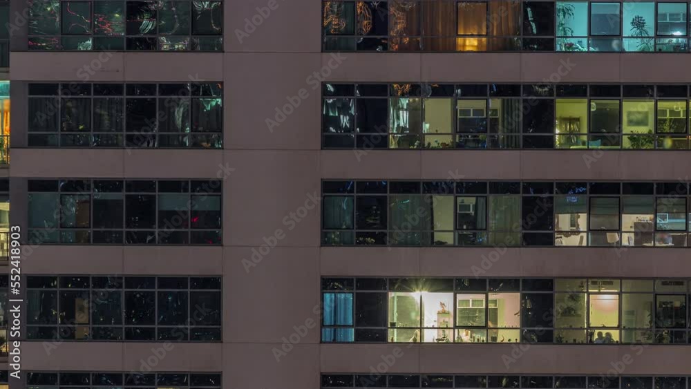 Windows lights in modern apartment buildings timelapse at night. Multi-level skyscrapers with illuminated rooms inside Windows lights in modern apartment buildings timelapse at night. Multi-level skyscrapers with illuminated rooms inside