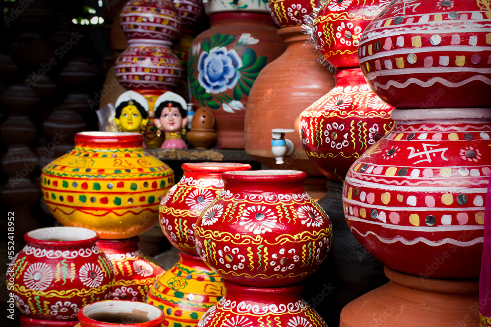 Beautiful red indian pots painted in white, green and yellow color flowers and line designs