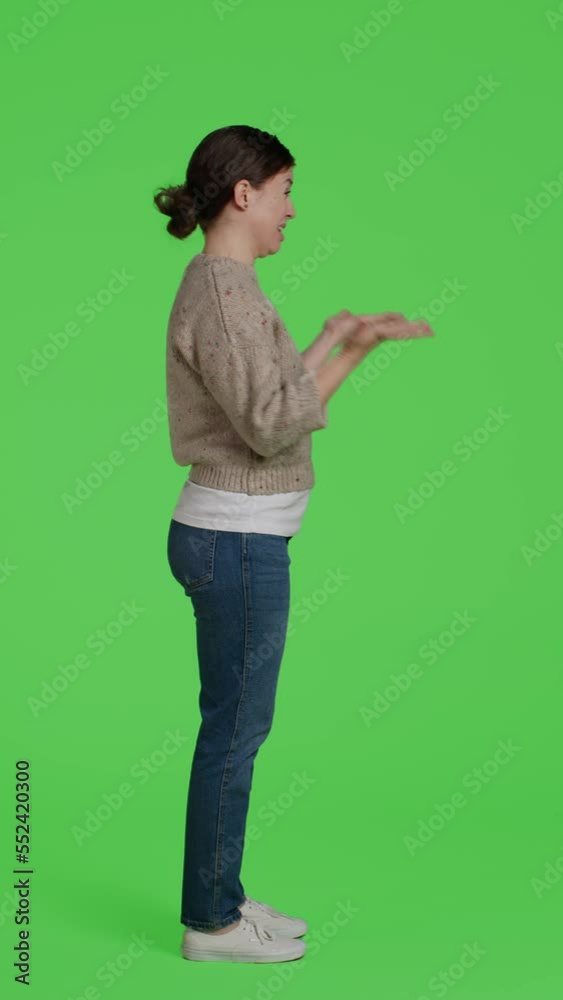 Vertical video: Profile of upset frustrated woman acting angry on full body greenscreen, showing disagreement and disapproval over green screen backdrop. Mad displeased girl being disappointed in Vertical video: Profile of upset frustrated woman acting angry on full body greenscreen, showing disagreement and disapproval over green screen backdrop. Mad displeased girl being disappointed in
