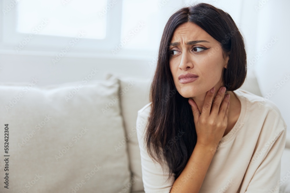 Woman sitting on sofa at home pain in nose and throat, cold and allergy, covid-19 disease, temperature Woman sitting on sofa at home pain in nose and throat, cold and allergy, covid-19 disease, temperature