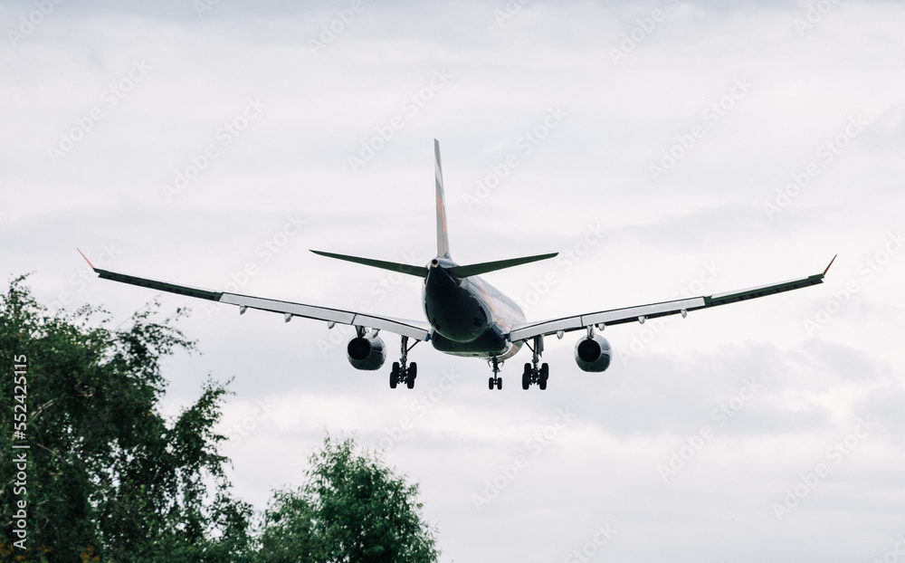 Obraz premium Passenger plane comes in for landing in cloudy weather.