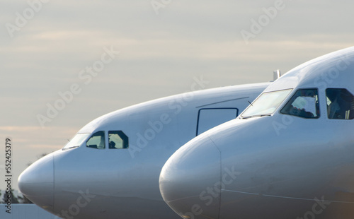 A modern passenger plane in white livery at the international airport on a cloudy morning.