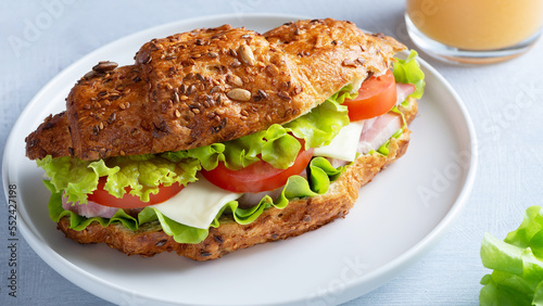 Croissant sandwich with meat, vegetables and cheese white background. Breakfast food concept